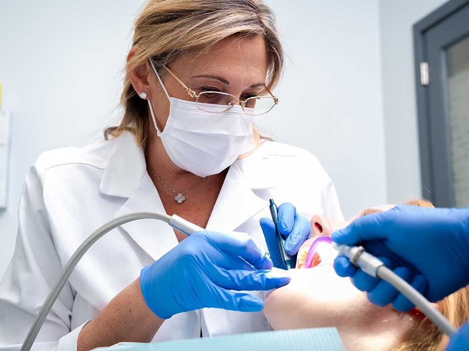 Dentist performing dental crown procedure at Dental Pearl Miami in North Miami Beach FL restoring damaged tooth