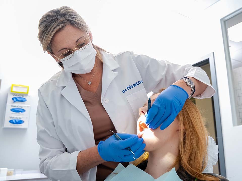 Dentist examining patient for bleeding gums and gum disease at Dental Pearl Miami in North Miami Beach FL