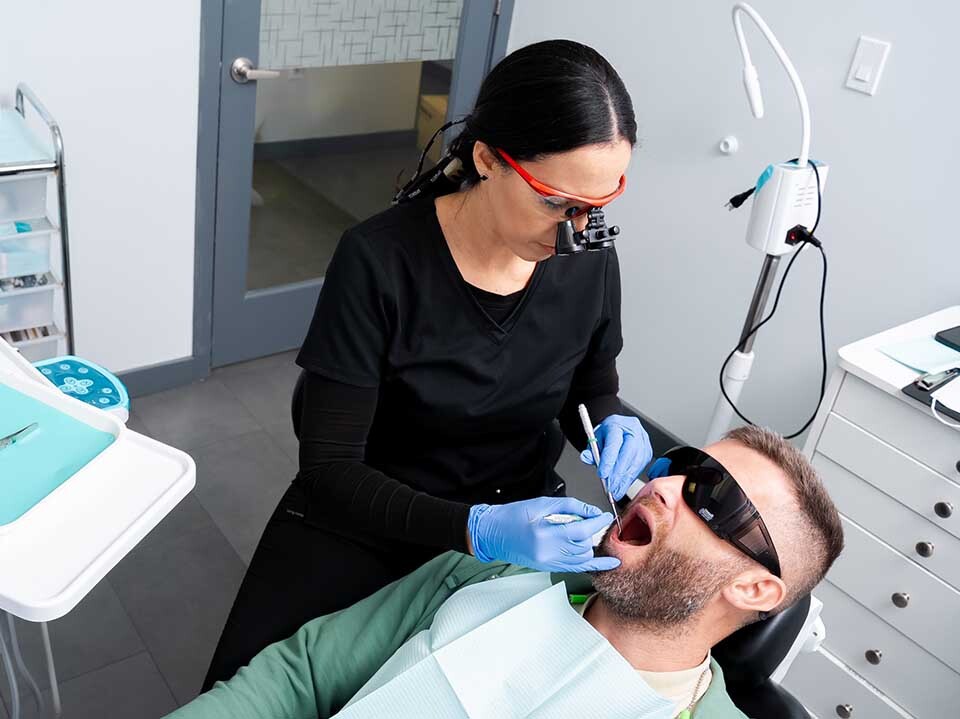 Dentist treating broken tooth and performing dental repair at Dental Pearl Miami in North Miami Beach Florida