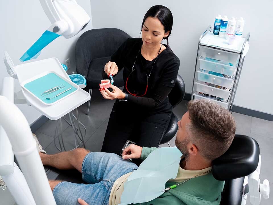 Dentist performing denture implant treatment at Dental Pearl Miami in North Miami Beach on Biscayne Blvd, restoring missing teeth with implant-supported dentures