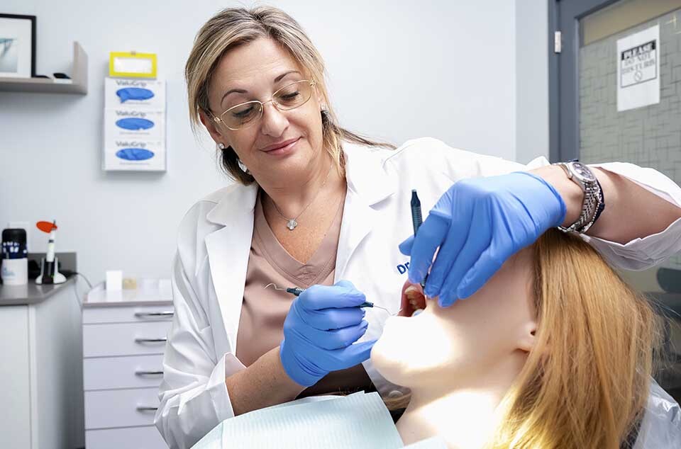 Dental hygienist performing professional teeth cleaning and deep gum cleaning for gingivitis treatment at Dental Pearl in North Miami Beach FL