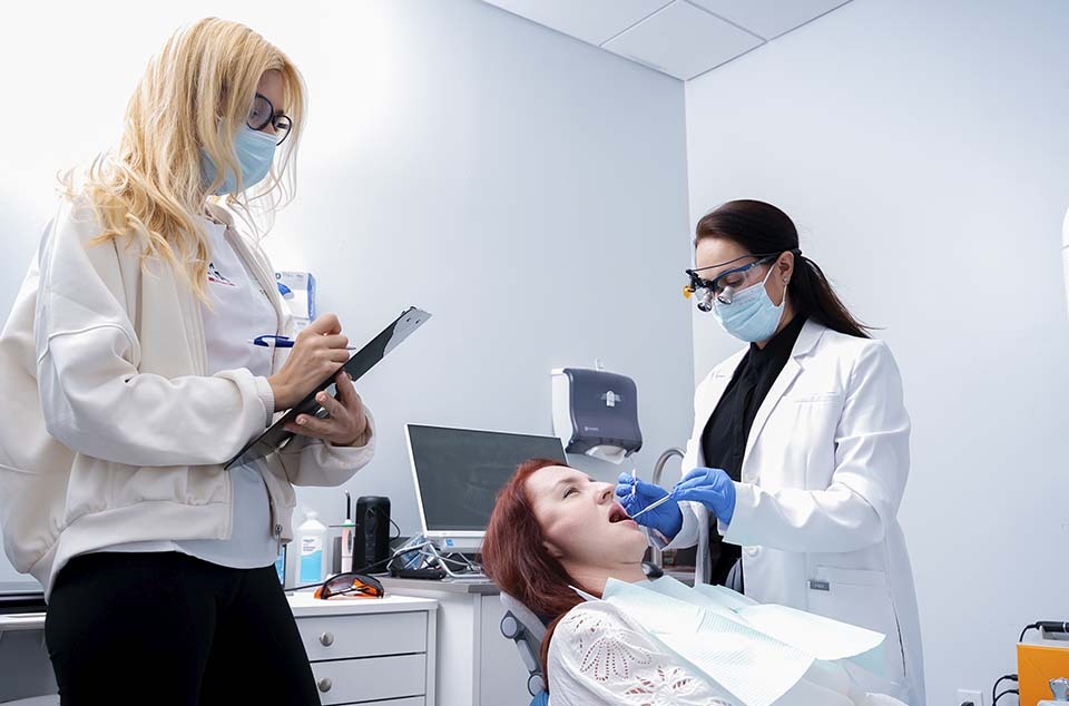 Dentist performing scaling and root planing as part of periodontitis treatment options in North Miami Beach FL