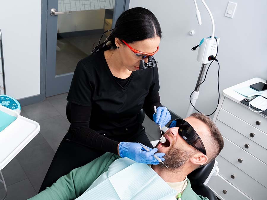 Dentist performing restorative dental treatment to repair damaged teeth at Dental Pearl Miami in North Miami Beach FL