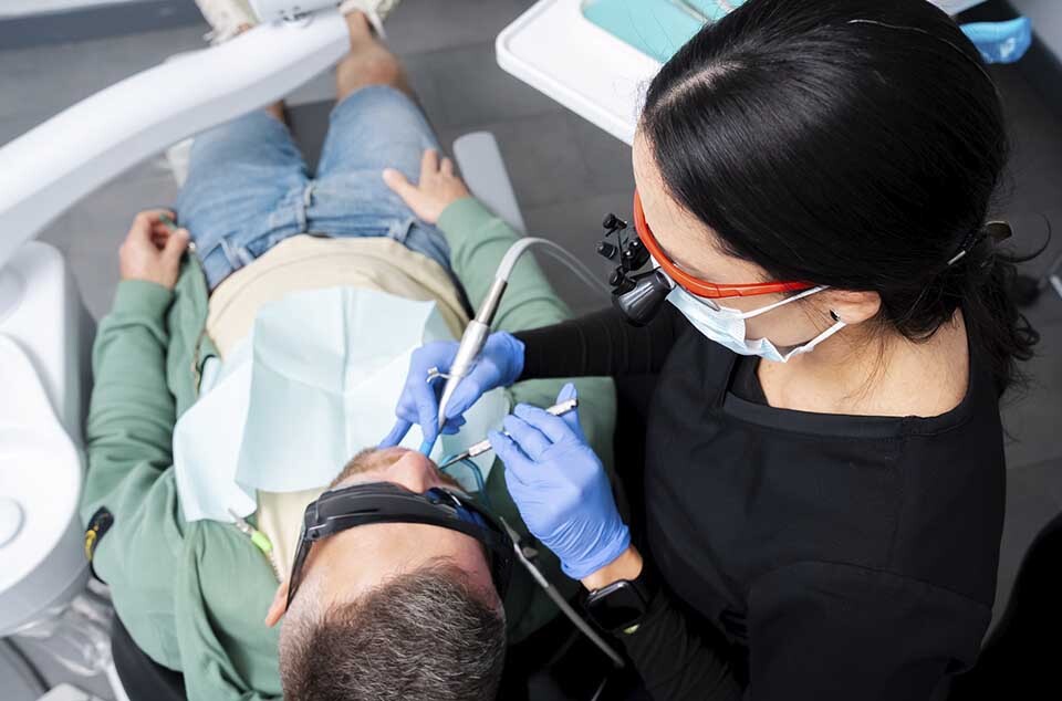 Dentist treating tooth decay with dental instruments at Dental Pearl Miami in North Miami Beach FL