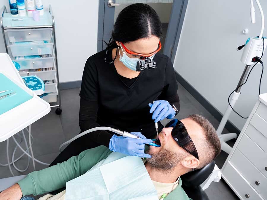 Dentist performing bone graft procedure during periodontal treatment at Dental Pearl Miami in North Miami Beach FL