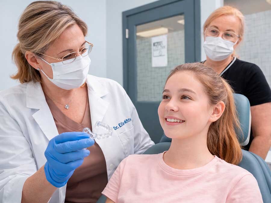 Teen patient during Invisalign consultation with dentist demonstrating clear aligners in North Miami Beach dental clinic