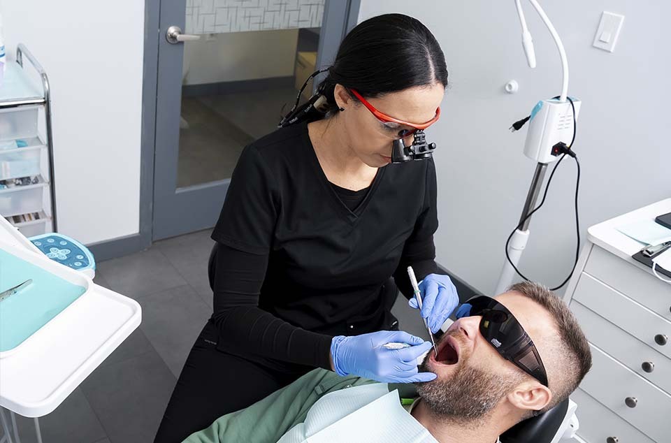 Dentist providing periodontal treatment for gum disease including gingivitis and periodontitis at Dental Pearl Miami in North Miami Beach FL
